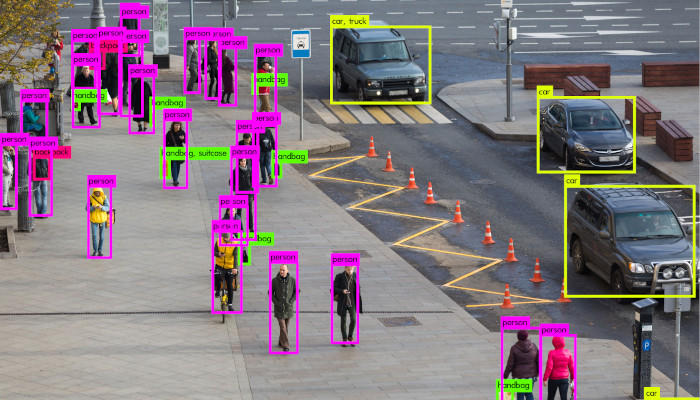 Computer vision tracks pedestrians and a black SUV on a tiled urban street.